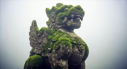 A weathered stone dragon statue covered in green moss, set against a backdrop of a foggy sky.
