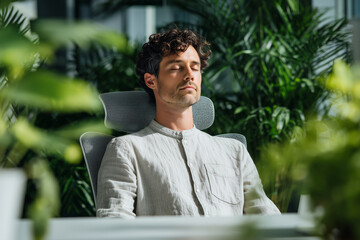 Hispanic man taking a mindful breathing break at his desk in a modern office. Calm, inclusive wellness moment with natural light and professional workspace. Latin businessman taking a break in office,