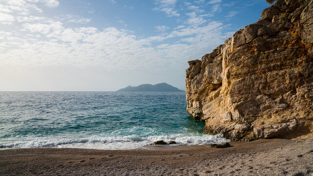 Rocky Beach With Turquoise Sea and Distant Island - Powered by Adobe