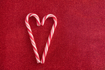 Christmas Candy canes as love heart on red background with copy space © RenaMiller