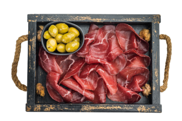 Italian bresaola with green olives served in a rustic wooden tray, photographed top view on a light background for gourmet charcuterie styling..
