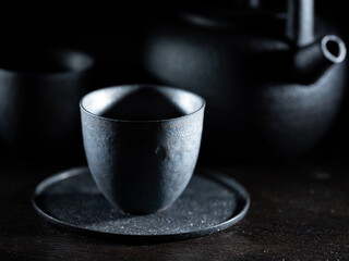 Black teacup on dark background,