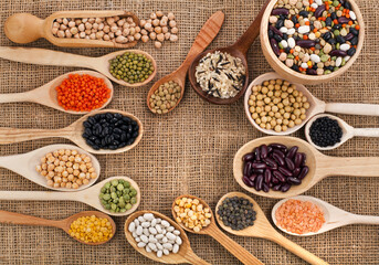 Various grain, beans, legumes, peas, lentils in spoon on the sackcloth background