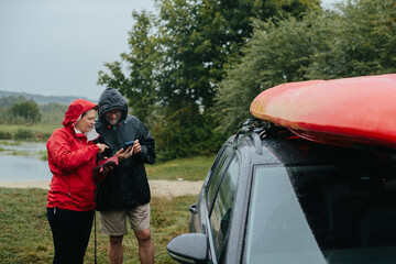 Senior couple checking map on phone before kayaking