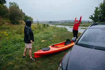 Senior couple enjoying outdoor kayaking in the rain
