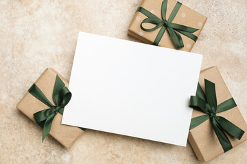 Greeting card mockup with blank copy space surrounded by beautifully wrapped gift boxes featuring green ribbons, perfect for christmas holidays celebrations and special occasions