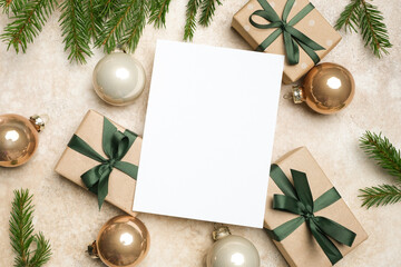 Christmas greeting card mockup with blank copy space surrounded by beautifully wrapped gift boxes and festive ornaments, creating a warm holiday atmosphere