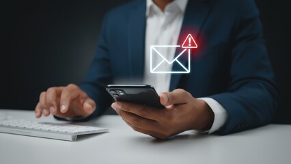 Business professional receiving a spam or virus email alert on their mobile phone device while at work