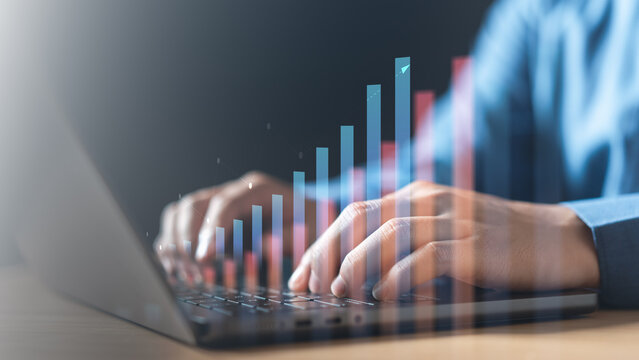 Close-up view hands typing laptop with digital bar charts and analytical graphics overlay, representing data analysis, business insights, and performance monitoring in modern digital workspace.