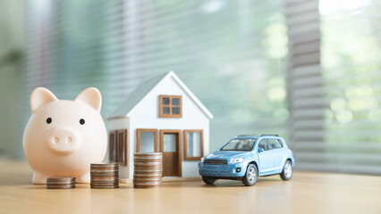 Piggy bank, stacked coins, model house, and toy car arranged together to represent late payment alerts, financial penalties, and overall money management for housing, loans, and personal budgeting.
