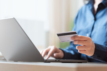 A person holding a credit card while typing on a laptop, representing secure online payments, digital transactions, and reliable financial processing in a modern and protected digital environment.