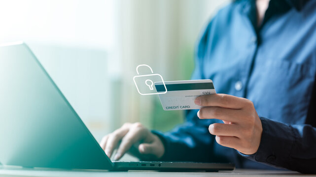 person holding credit card while using laptop, illustration secure online payments, fraud prevention, digital banking protection in modern and safe financial environment. Card freeze and lock controls