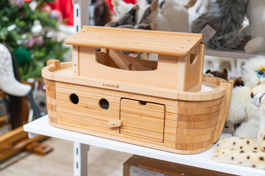 Wooden Noahs Ark toy with open lid, standing on white surface Empty interior with figurine stands and a functional door Background contains plush animals, stuffed - Kyiv, Ukraine - November 12, 2025