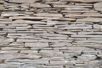 Natural stone wall. Flagstone masonry. Stone texture, gray background.