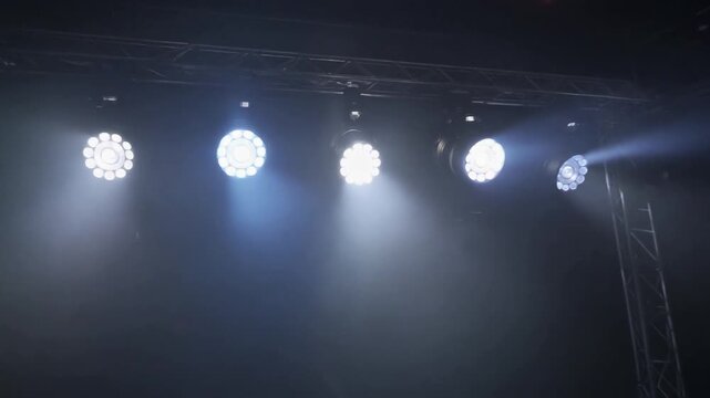Stage lighting rig with multiple bright L E D P A R cans illuminating a dark smoky atmosphere