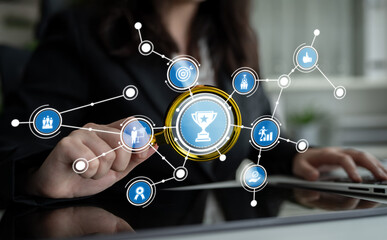 A business professional engages with digital icons representing achievement and success, showcasing modern technology in a dynamic workspace. Crux