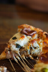 Macro close-up of a hot pizza slice with melted cheese pull, herbs, and savory toppings. Warm natural lighting and shallow depth of field ideal for menus, ads, blogs, and food marketing.