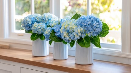 Three elegant vases filled with vibrant blue hydrangeas on a sunny windowsill with greenery outside