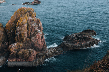 Dramatic ocean seascape with rugged rocky cliffs and crashing waves