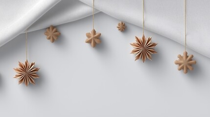 Minimalist cozy winter composition with several brown and beige paper star ornaments hanging from the bottom hem of an elegant white curtain on a neutral backdrop.