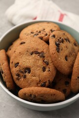Delicious chocolate chip cookies in bowl on table, closeup