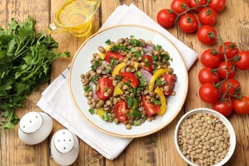 Tasty lentil salad with ingredients on wooden table, flat lay