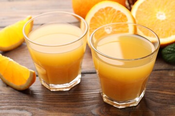 Fresh orange juice and fruits on wooden table, closeup