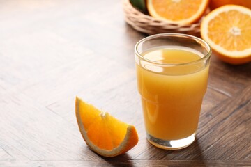 Fresh orange juice and fruits on wooden table, closeup. Space for text