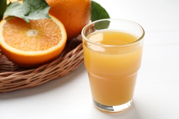 Fresh orange juice and fruits on white table, closeup