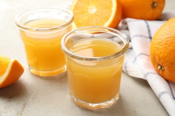 Fresh orange juice and fruits on light table, closeup