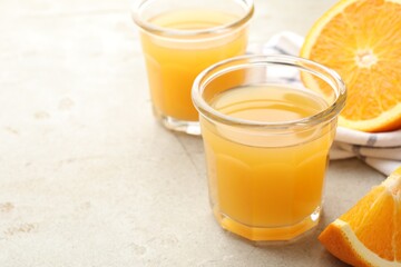 Fresh orange juice and fruits on light table, closeup. Space for text