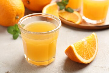 Fresh orange juice, mint and fruits on light table, closeup