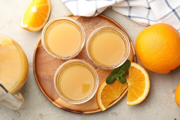 Fresh orange juice, mint and fruits on light table, flat lay