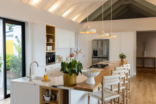 Two-tiered kitchen island featuring quartz countertop, sink, lemon bowl in modern kitchen