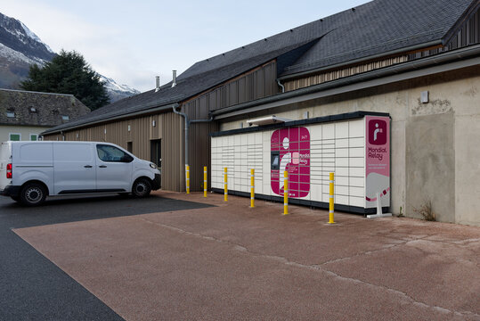 Point relais Mondial Relay avec casiers automatiques devant un b&acirc;timent commercial et fourgon utilitaire
