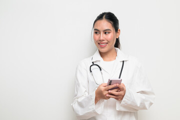 Fototapeta premium Woman Doctor with Stethoscope in White Uniform on Plain Background Using Phone