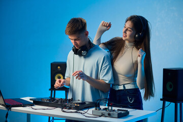 Music creators in studio, Studio session featuring musical synthesis and focused teamwork, Electronic music producers working together with various tools and instruments