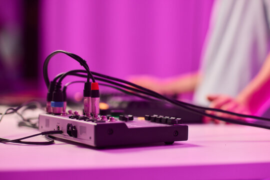 Closeup of tactile controls and vibrant patch cords in studio, Adjusting analog sequencing equipment with bright cables and warm ambient lighting in home studio