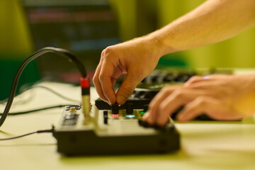 Closeup of tactile controls and vibrant patch cords in studio, Adjusting analog sequencing equipment with bright cables and warm ambient lighting in home studio