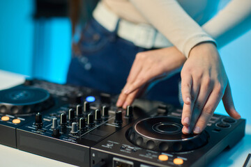 DJ setup overview, Energetic club DJ performing with digital controller in action, Content creator mixing music live using digital turntables under vibrant stage lights