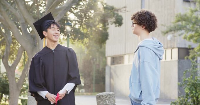 Post-ceremony diverse male friends on campus, untying diploma, recounting highlights, copy space