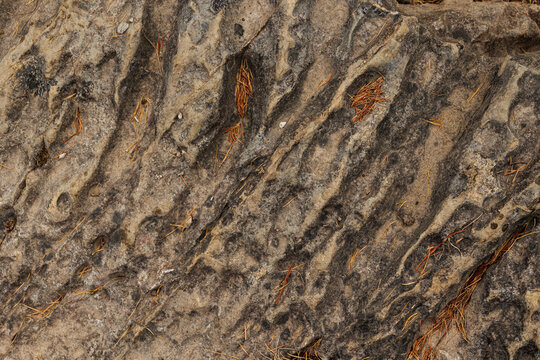 vista dettagliata della superficie imperfetta e piena di solchi di una roccia naturale ed antica, scavata dal tempo e dalle intemperie