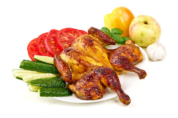 Roasted chicken with glazed skin on a white plate, served with sliced tomatoes, cucumbers, and yellow peppers, isolated on white background.