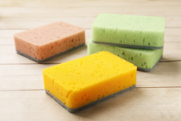 Clean kitchen sponges on wooden table, closeup