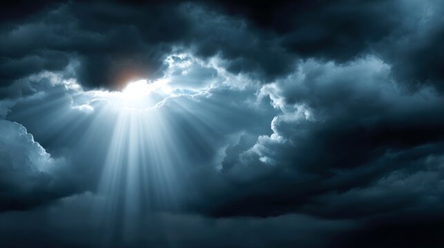 Majestic sunbeams shining through dark clouds over mountains and fields