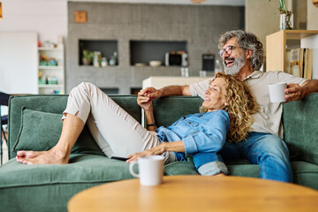 Obraz premium Portrait of a happy senior couple embracing talking at home