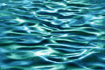 abstract water flow waves and ripples in closeup with reflections in blue aqua and green