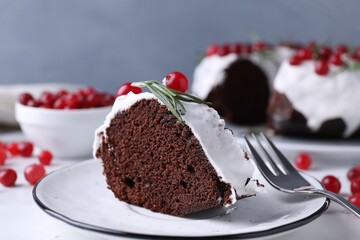 Tasty Christmas cake with cranberries and rosemary served on table, closeup