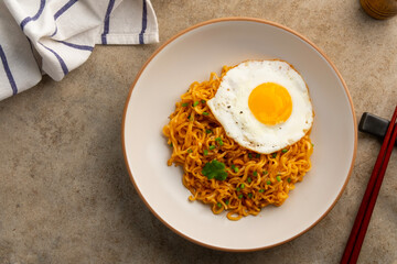 instant noodles and egg.dry noodles with shrimp tom yum soup flavour and fried egg in a plate.Top view.