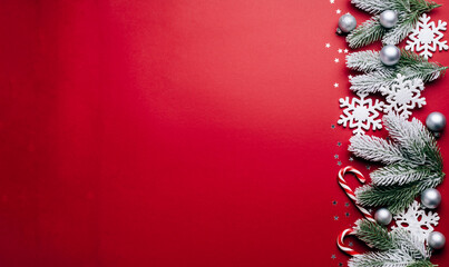 Christmas red background with winter holiday border of frosted pine branches and snowflakes